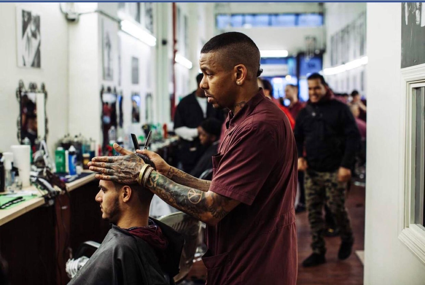 Barber cutting client in busy shop