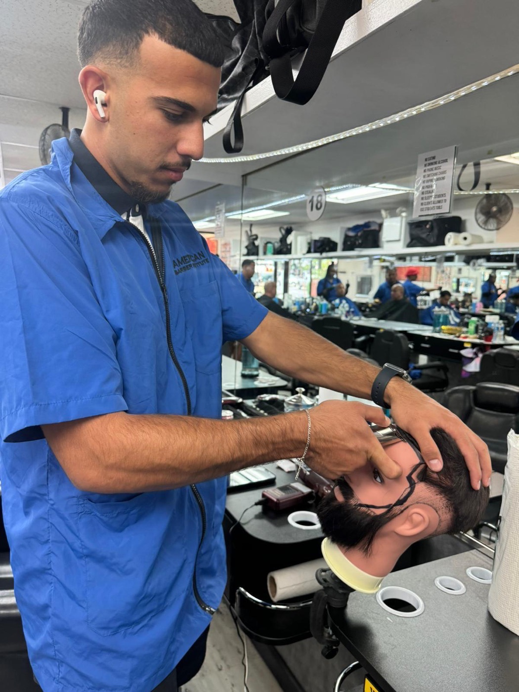 Student trims client's beard at station