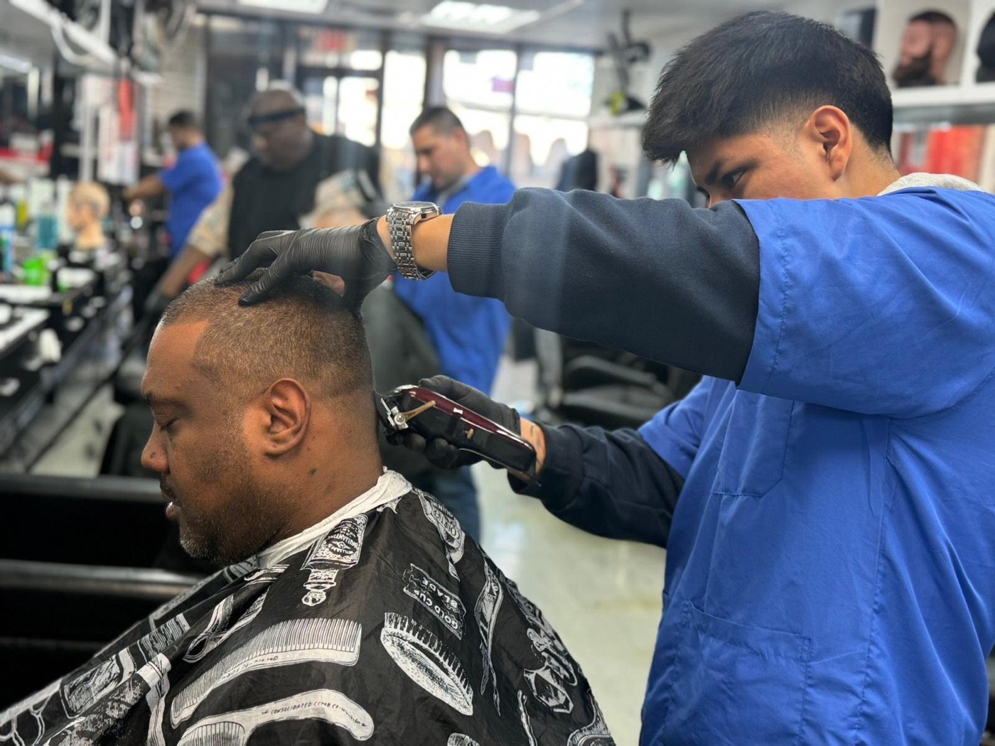 Student clipper-cuts client's hair