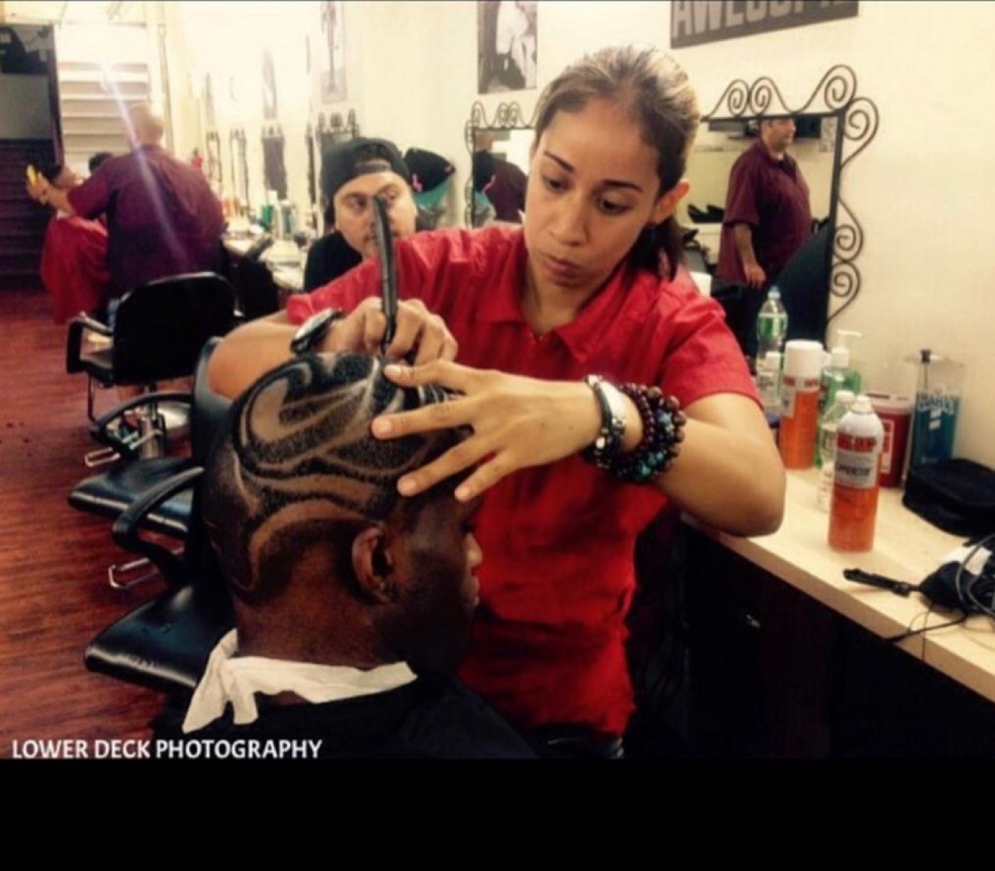 Barber carving hair design on client