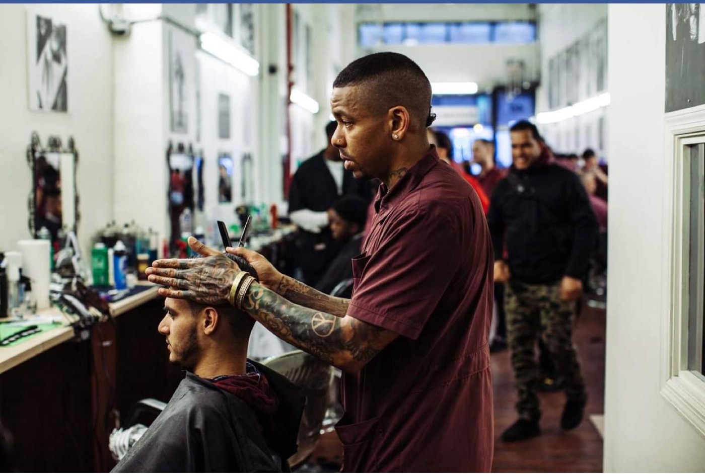 Barber cutting client in busy shop