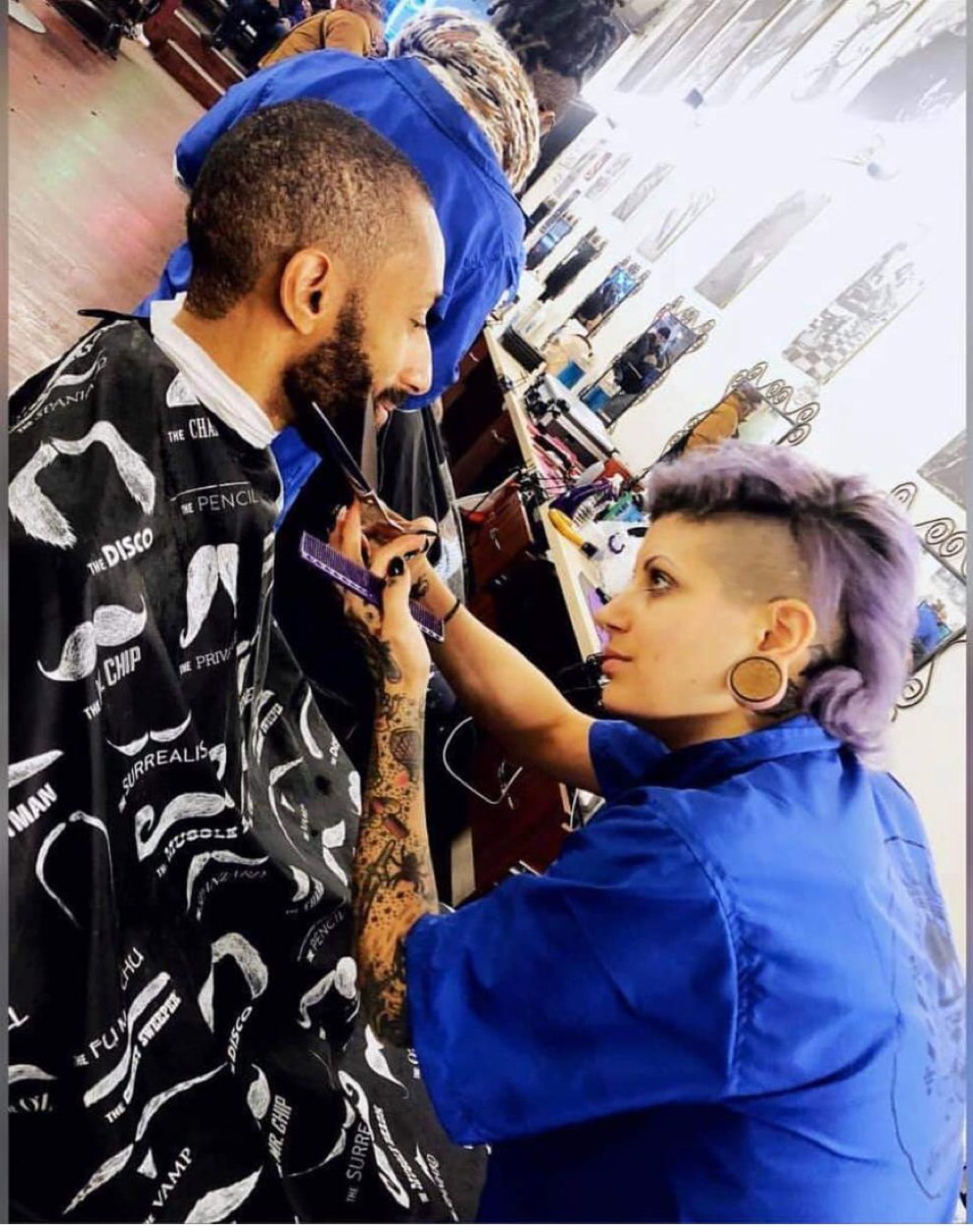 Student trimming client beard closely