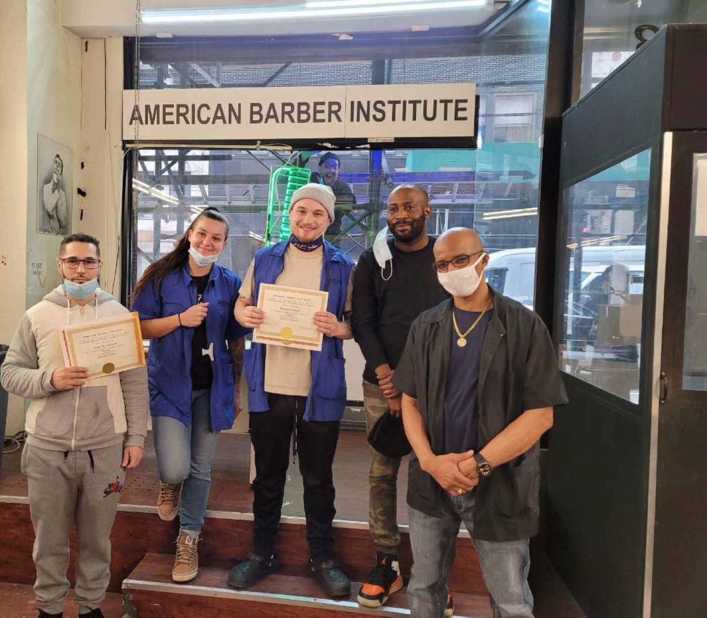 An ABI instructor presenting a Certificate of Completion to a beaming graduate