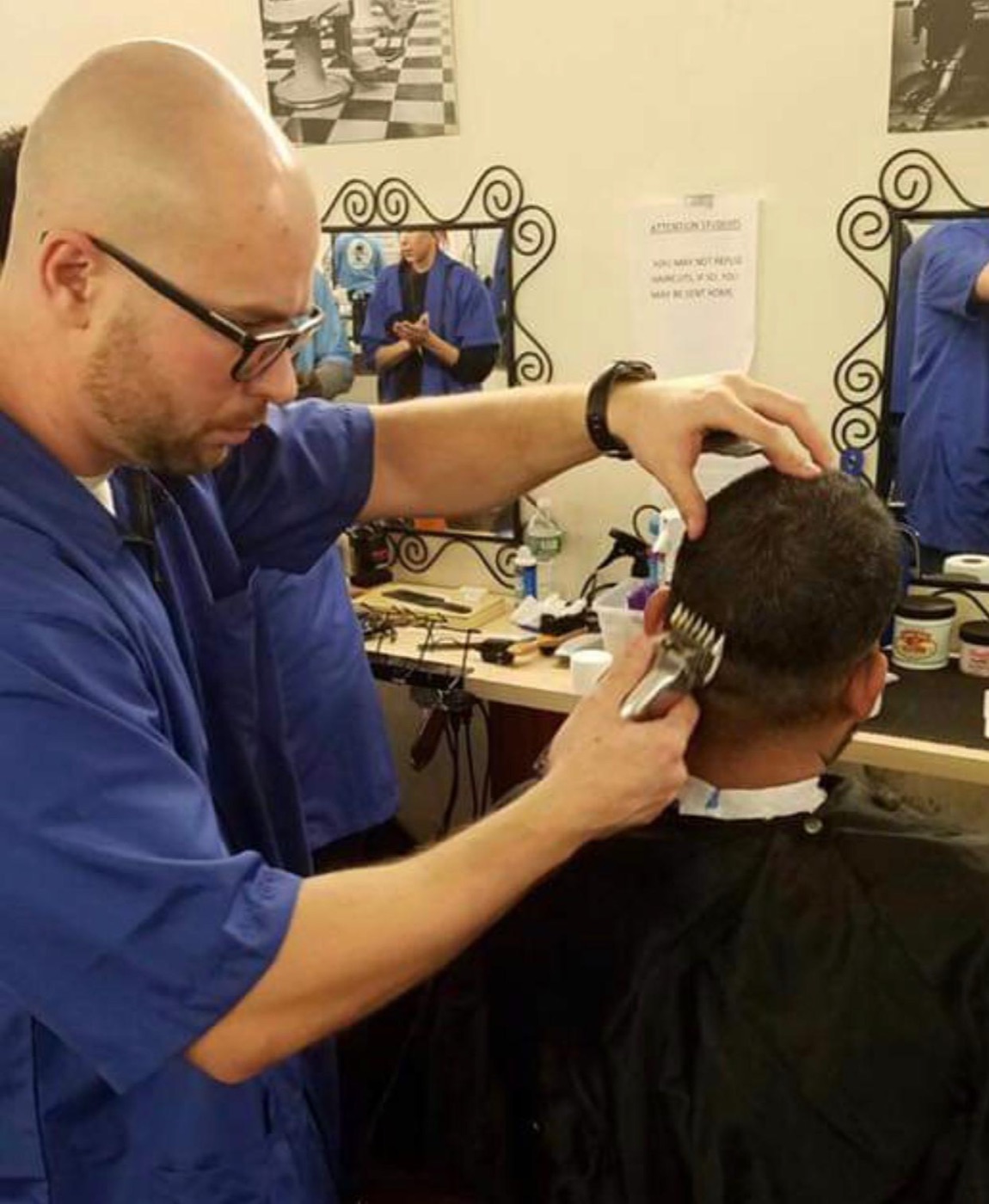 An ABI student practicing a precise fade on a client during hands-on training
