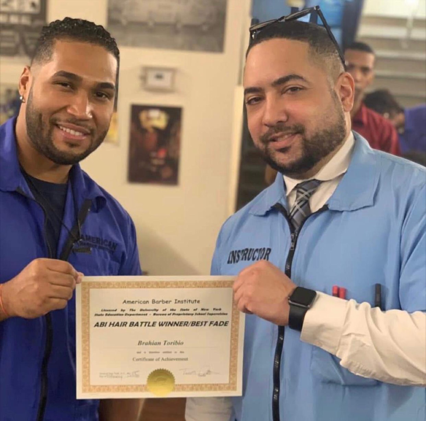 An ABI instructor and student holding up a Best Fade achievement certificate together